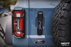 Close-up of a blue Ford vehicle door with a NEFT product attached, showing brand logo.