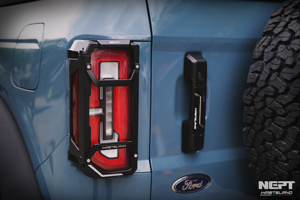 Close-up of a blue Ford bronco with the NEPT Wasteland rear tail light cover and door handles 