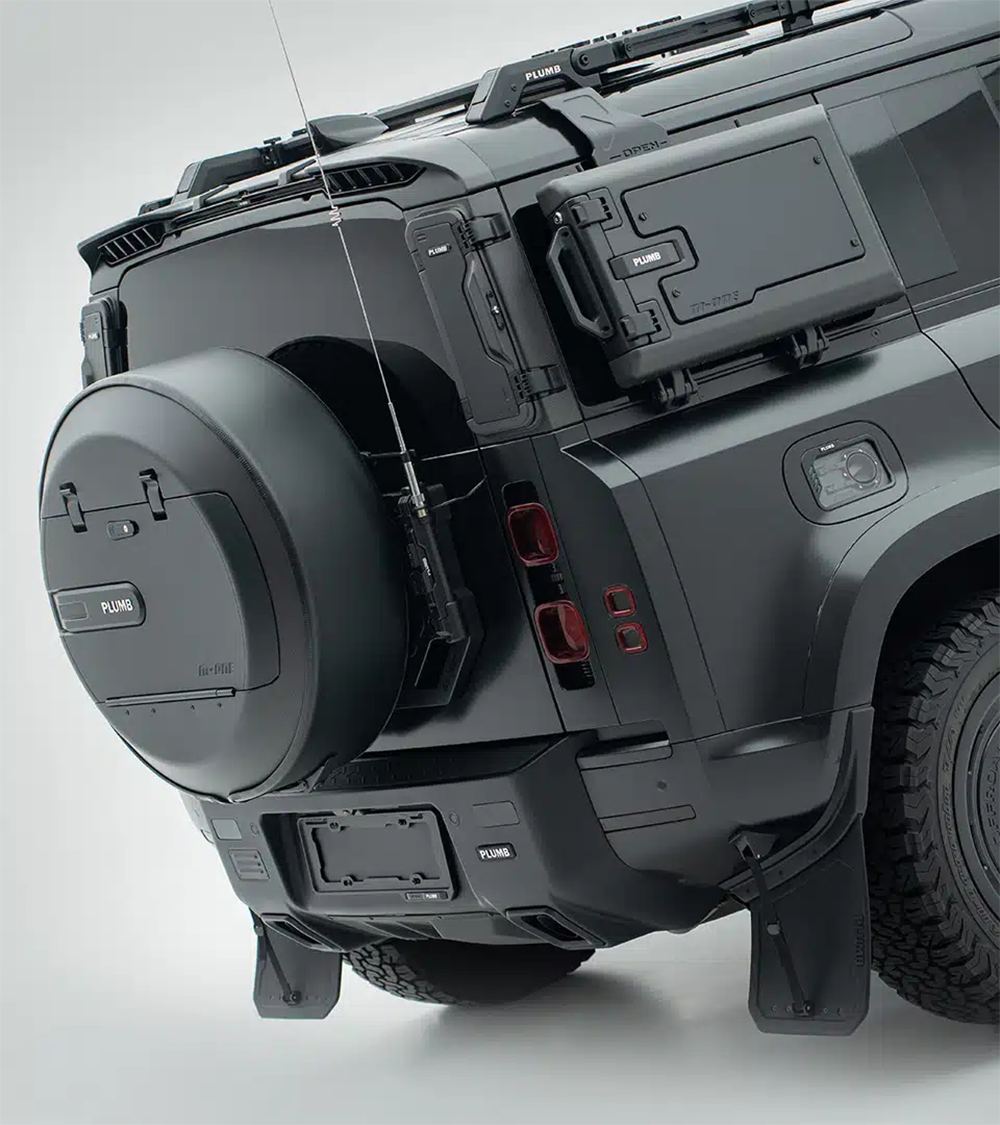 Full rear shot of a Land Rover Defender equipped with the PLUMB heavy-duty bumper and integrated step for enhanced off-road utility.